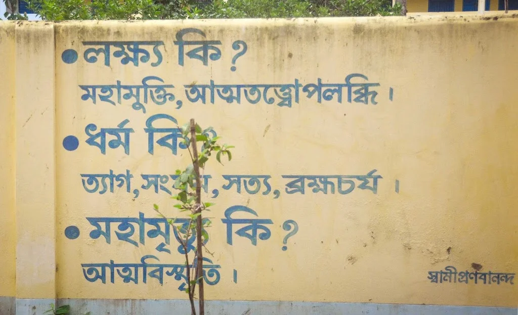 Quote on determination by Swami Pranavananda at Naogaon Sevashram Sangha wall.