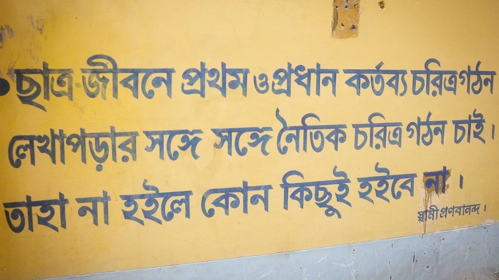 Swami Pranavananda Ji Maharaj's Bangla quote on student life at Naogaon Sevashram Sangha wall.