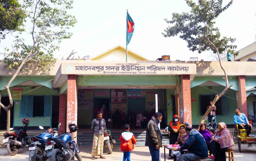 A clear day photo of Mohadevpur Union Parishad Office under Mohadevpur Upazila of Naogaon district.