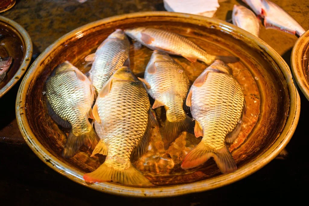 Live fish on a tray with water at town fish market.