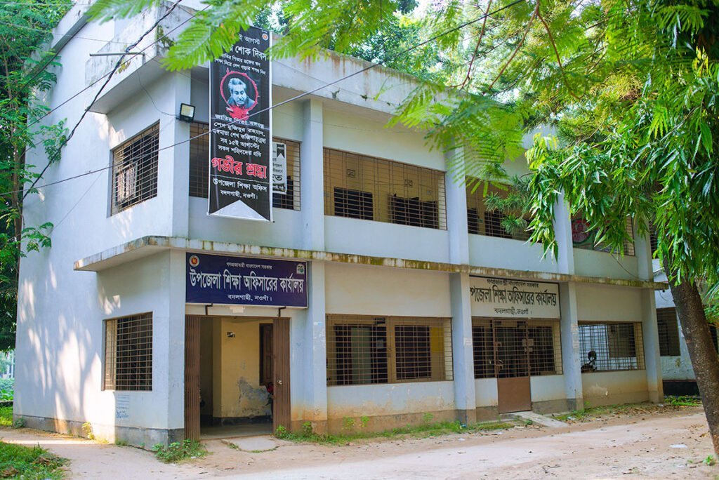 The two-storied building of the Badalgachhi Upazila Education Office, also home to the Upazila Education Officer, within the upazila complex.