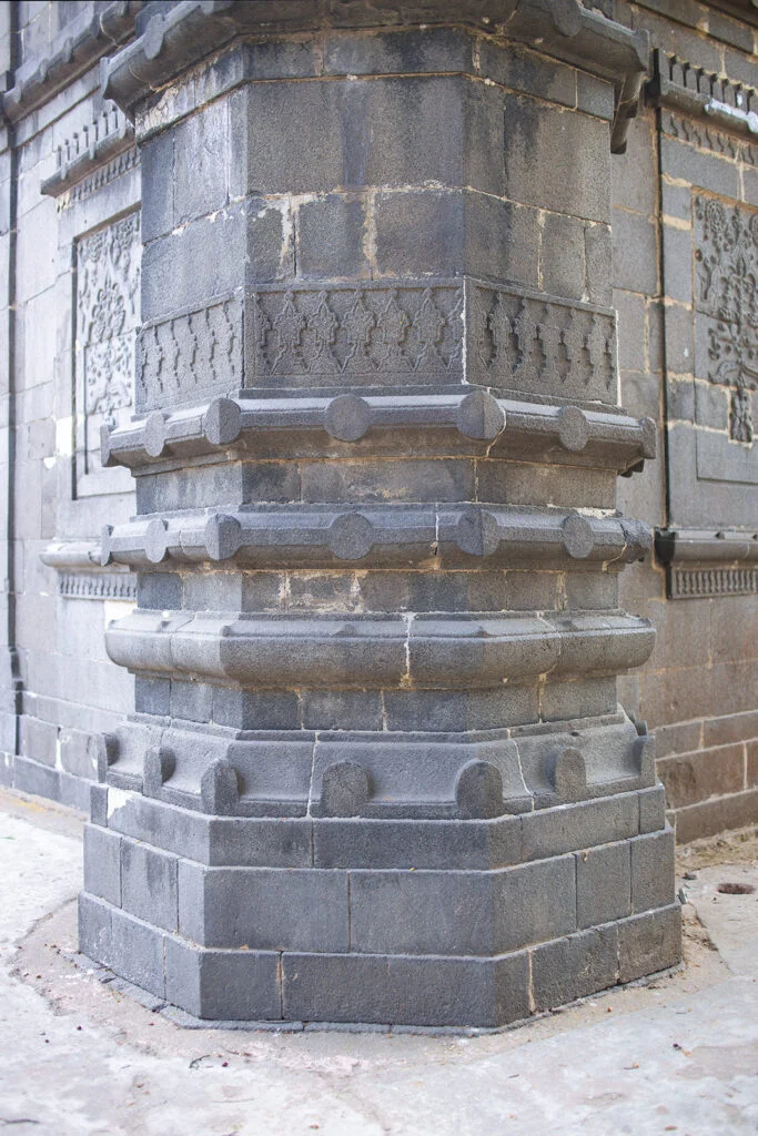 Corner pillar of mosque adorned with black stone artwork.
