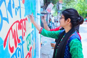 A student painting wall graffiti in Naogaon, Bangladesh, on 17th August 2024.